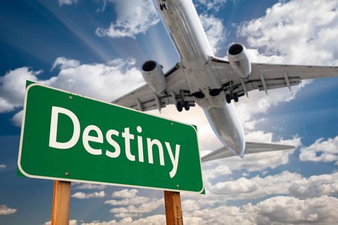 Destiny green road sign and airplane above with dramatic blue sky and clouds
