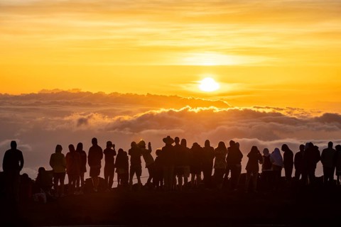 Touristen beobachten den Sonnenuntergang auf dem Gipfel des Haleakala Vulkan