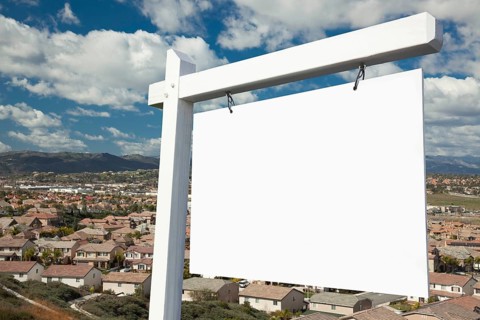 Blank real estate sign with elevated housing community view