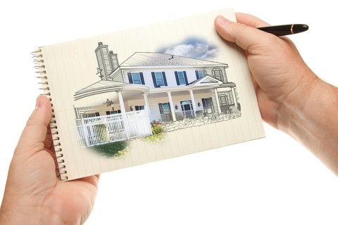 Male hands holding pen and pad of paper with house drawing isolated on a white background