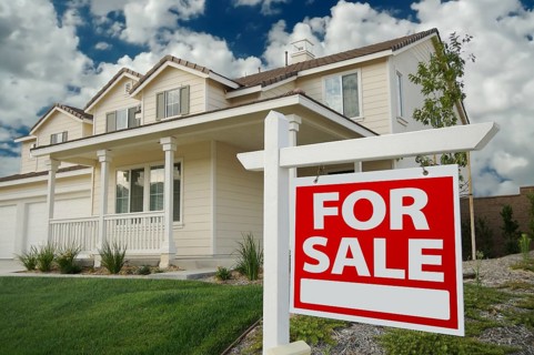 Home for sale real estate sign in front of new house