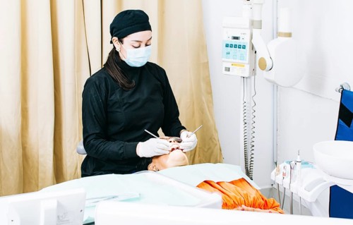Woman dentist with patient lying down
