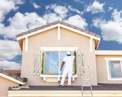 Busy house painter painting the trim and shutters of A home