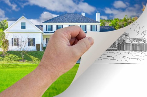 Male hand turning page of custom home photograph to drawing underneath