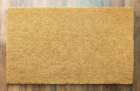 Blank welcome mat on wood floor background ready for your own text