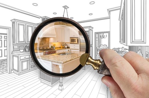 Hand holding magnifying glass revealing custom kitchen design drawing and photo combination