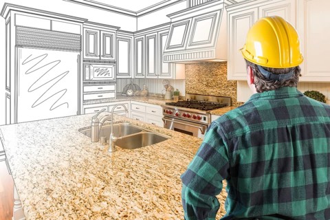 Male contractor with hard hat looking at custom kitchen drawing photo combination on white