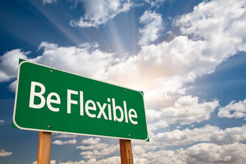 Be flexible green road sign with dramatic clouds and sky