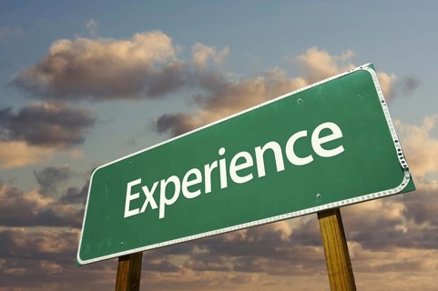 Experience green road sign with dramatic blue sky and clouds
