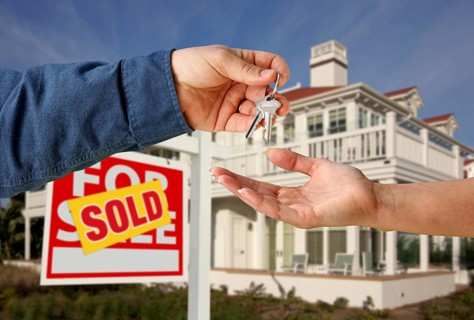 Handing over the house keys in front of a beautiful new home