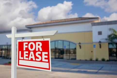 Vacant retail building with for lease real estate sign in front