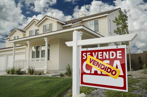 Home for sale real estate sign in front of new house
