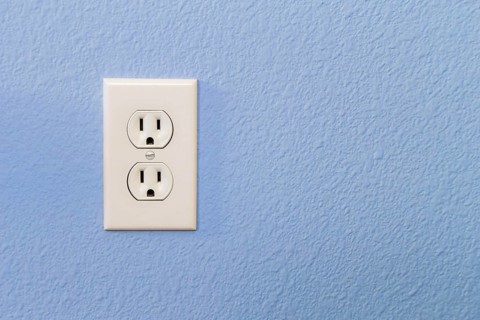 Electrical sockets in colorful blue wall of house