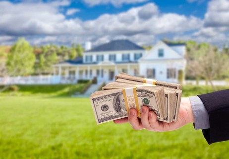 Handing over cash for house in front of beautiful new home