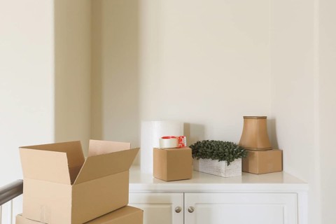 Variety of packed moving boxes and materials in empty room