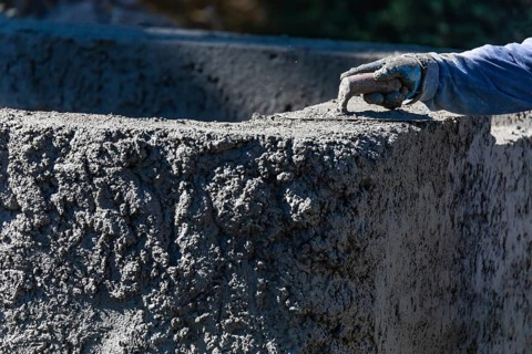 Pool construction worker working with A smoothing trowel on wet concrete