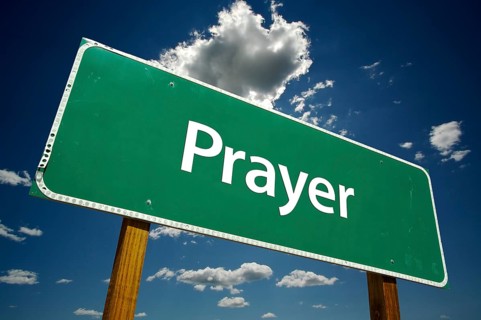 Prayer road sign with dramatic clouds and sky