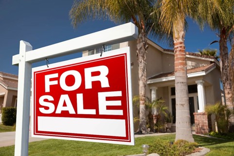 For sale real estate sign in front of house