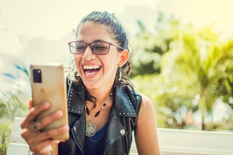 Close up of a happy girl checking her cell phone