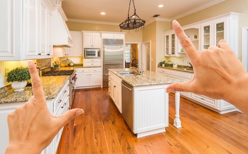 Female hands framing A beautiful custom kitchen interior