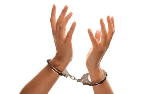 Handcuffed woman desperately raising hands in air isolated on a white background