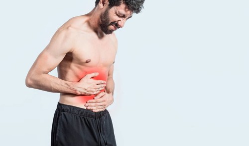 Shirtless man with stomach ache