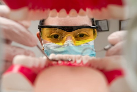 A dentist cleaning a mouth inside view