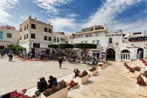 Cafe und Geschaefte mit Touristen auf der Plaza Nueva