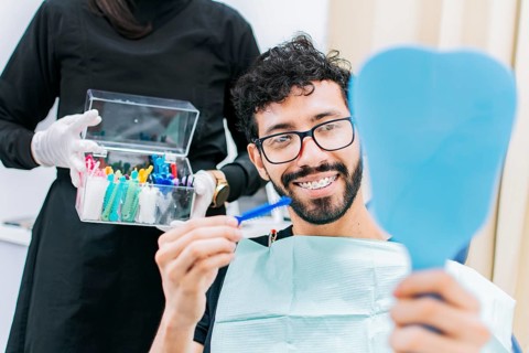 Dentist with patient choosing metal braces