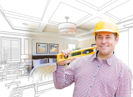 Smiling contractor in hard hat with level over custom bedroom drawing and photo combination