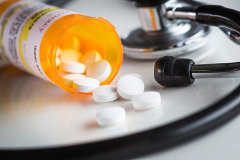 Non-Proprietary medicine prescription bottles and spilled pills abstract with stethoscope