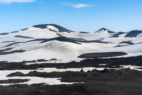 Barren hilly volcanic landscape of snow and lava fields