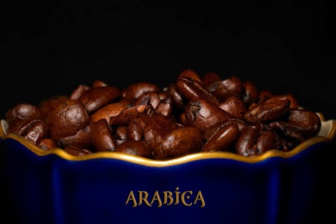 Roasted Arabica coffee in a porcelain cup in cobalt blue with gold rim and the inscription Arabica