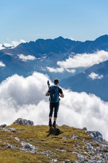 Hiker with climbing helmet on a steep rocky ridge