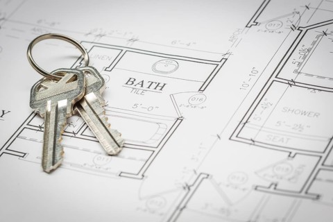 Set of new house keys resting on custom house plans