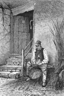 Basket weaver sitting in front of his house weaving a wicker basket