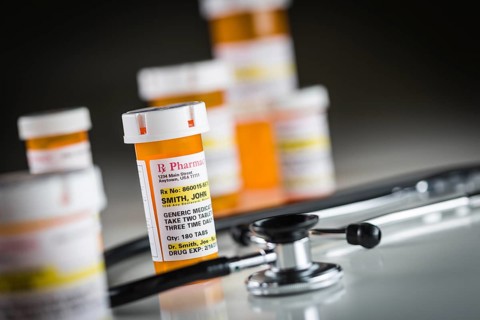 Several non-proprietary medicine prescription bottles abstract with stethiscope