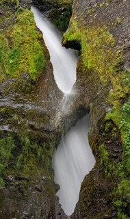 Waterfall behind two rock holes