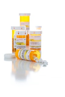Non-Proprietary medicine prescription bottles and spilled pills isolated on a white background