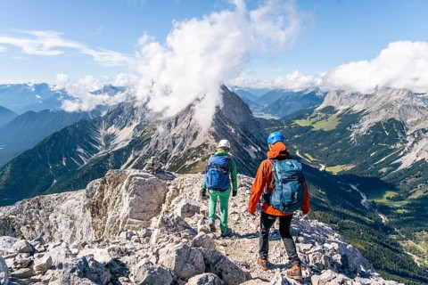 Hiker with climbing helmet on a steep rocky ridge