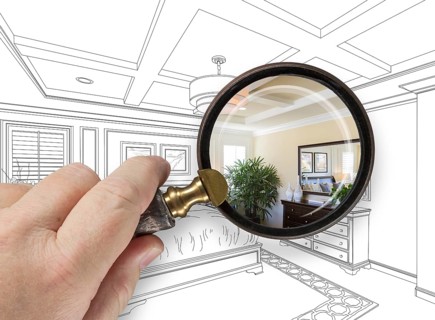Hand holding magnifying glass revealing custom bedroom design drawing and photo combination