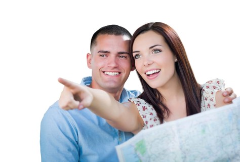 Young military couple looking at map isolated on white