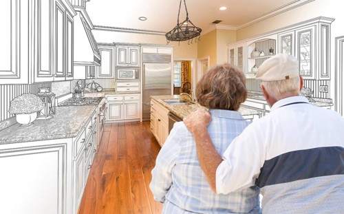 Senior couple looking over custom kitchen design drawing and photo combination