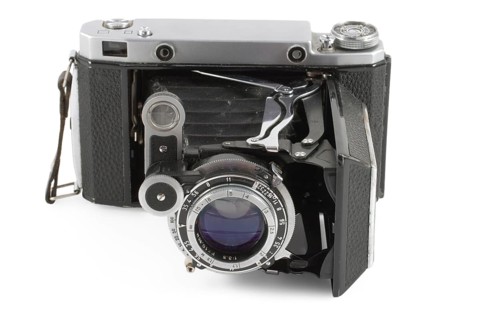 Old folding camera isolated on white background