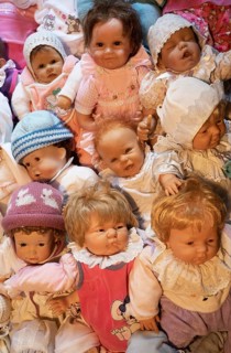 Various decorative dolls and baby dolls lying together