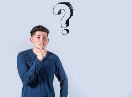Thoughtful young man looking up with exclamation marks