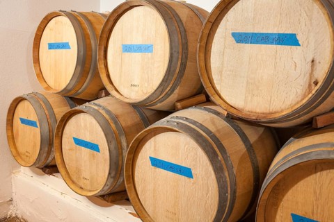 Several various wine barrels age inside cellar