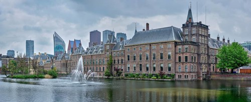 Panorama of the Binnenhof House of Parliament and the Hofvijver lake with downtown skyscrapers in background