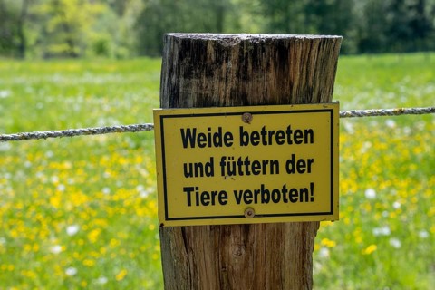 Sign 'Do not enter the pasture or feed the animals!' at a meadow in the Reitlingstal