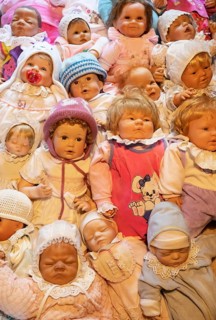 Various decorative dolls and baby dolls lying together